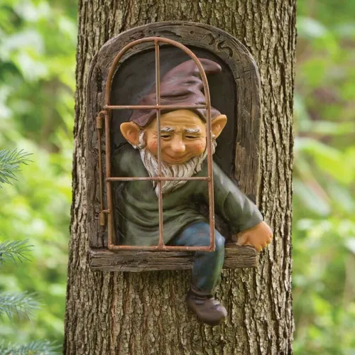 Nain de jardin sortant d’un tronc d’arbre
